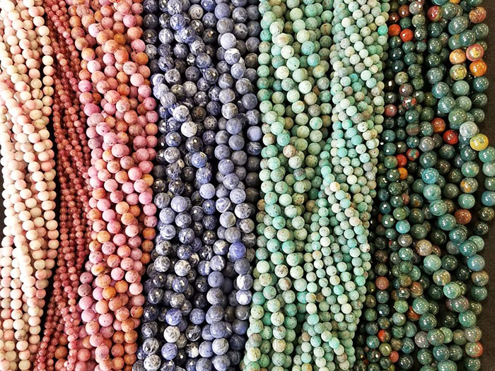 Strings of shiny pearl beads in pastel pink, purple, and green.
