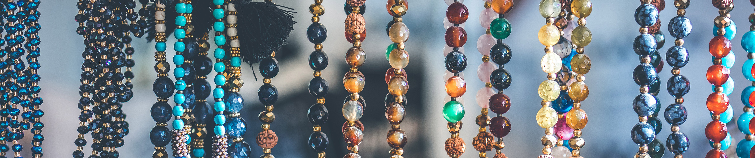 Strings of colorful beaded necklaces hanging in the air.