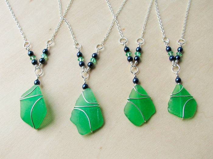 Green sea glass pendants with silver wire wrapped around them.