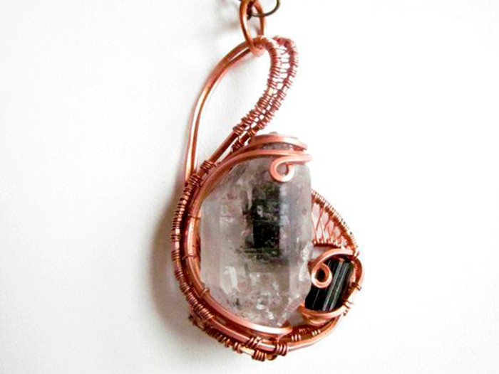 Crystal wrapped in intricate copper wire.
